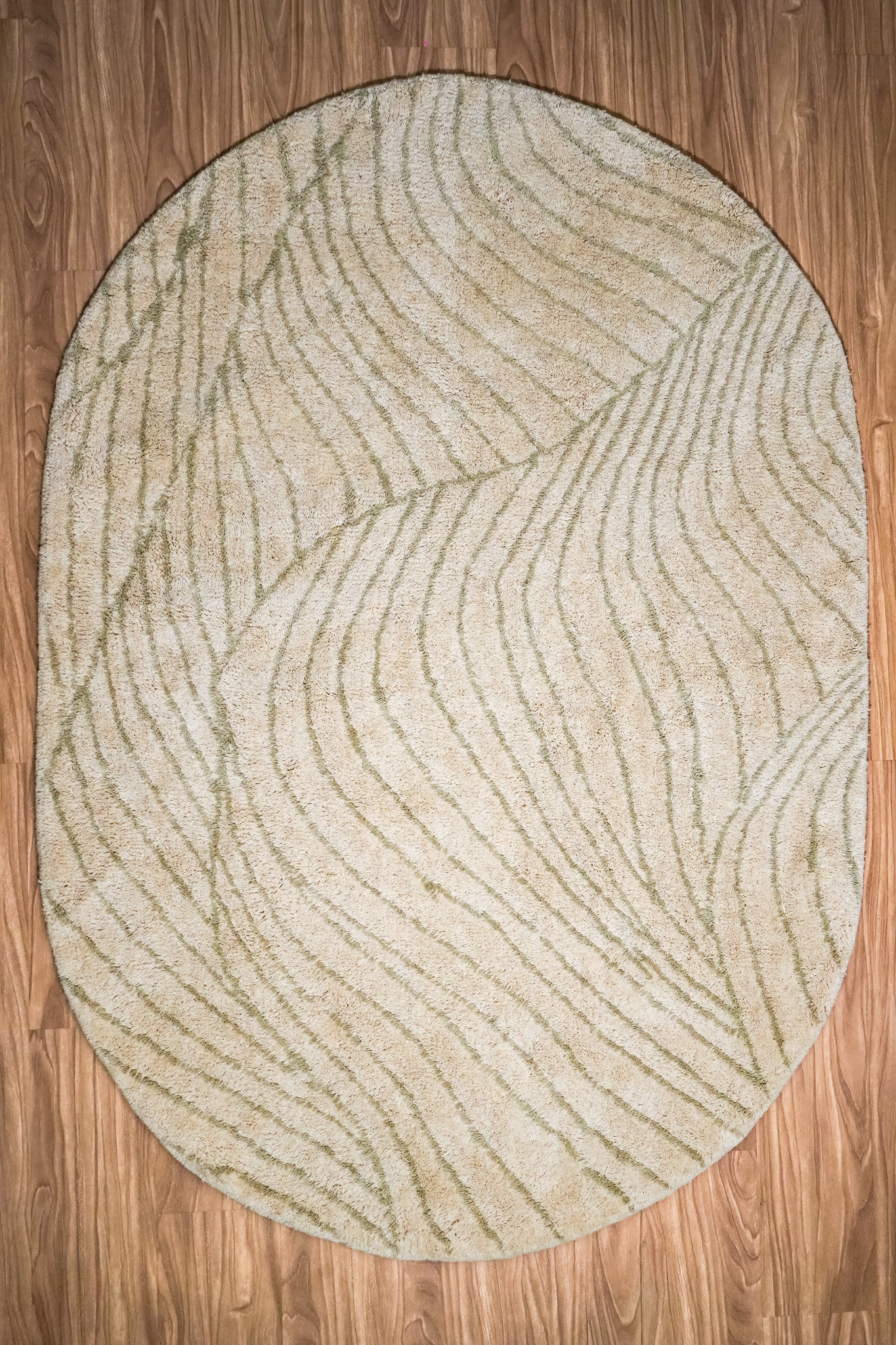 Modern wave hand-tufted oval wool rug in tonal grey showing subtle curved pattern detail