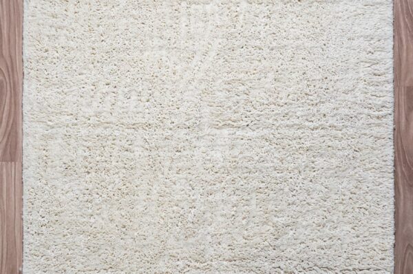 Moroccan-inspired handwoven shaggy wool rug in neutral oatmeal with natural texture variation