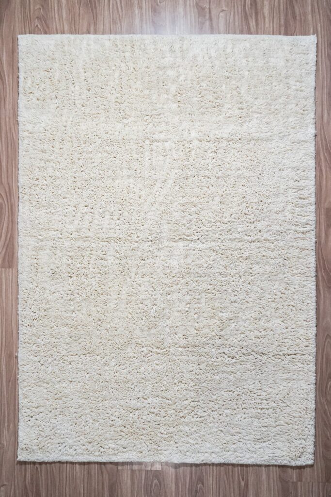 Moroccan-inspired handwoven shaggy wool rug in neutral oatmeal with natural texture variation