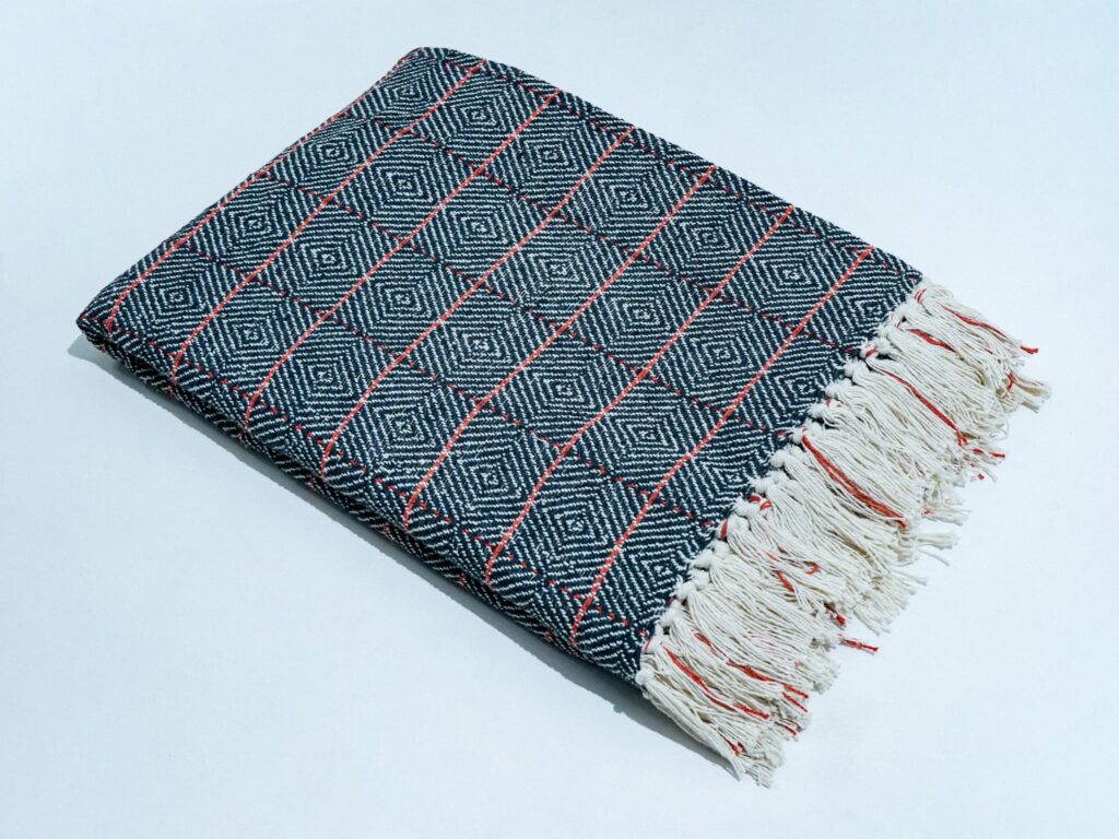 Cross Check Throw in black, STCT-139 E, styled in a living room setting