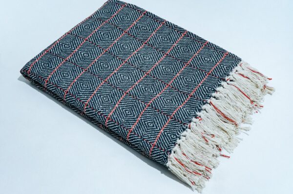 Cross Check Throw in black, STCT-139 E, styled in a living room setting