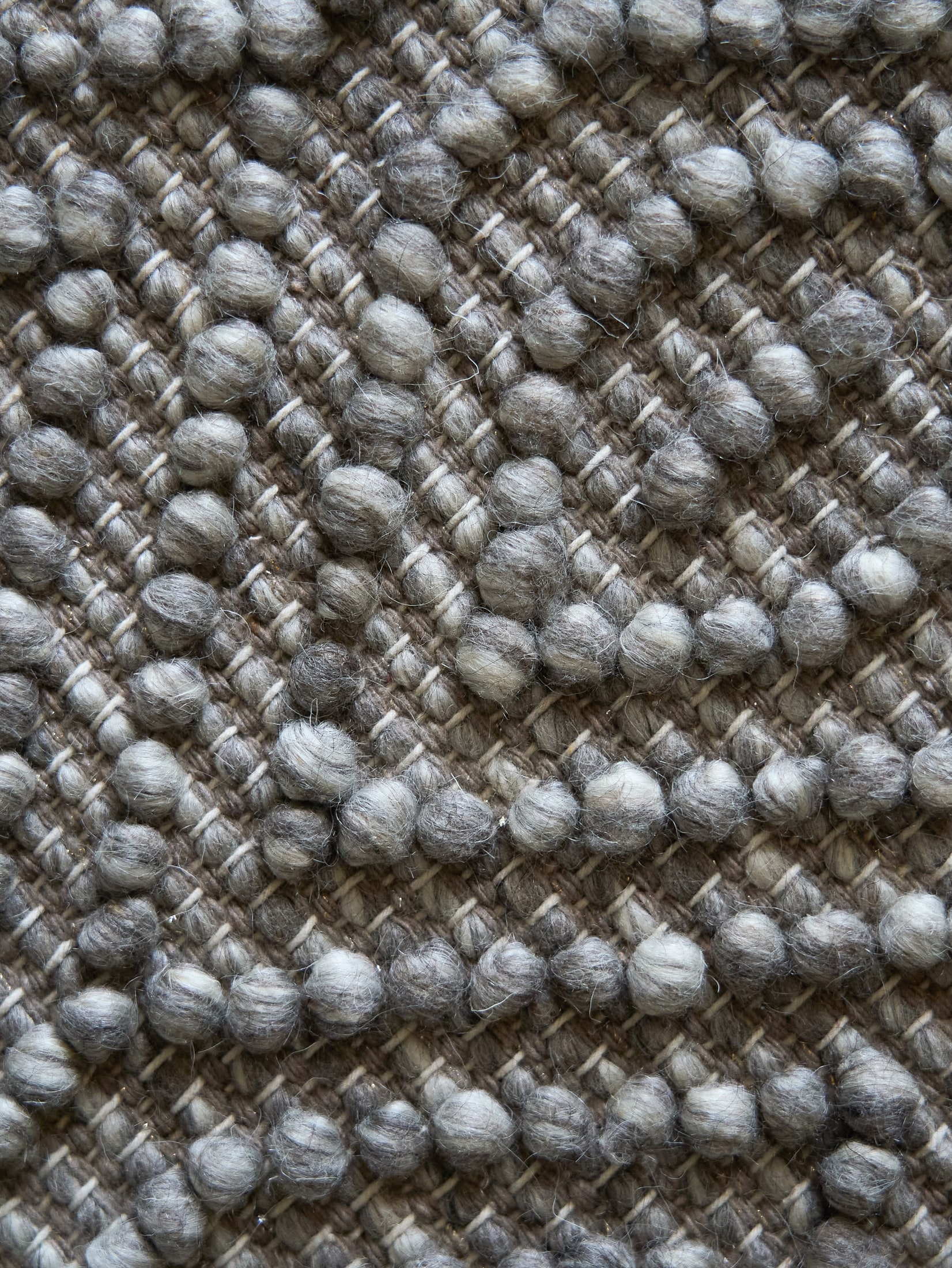Close-up of the grey rug surface showing its looped texture.