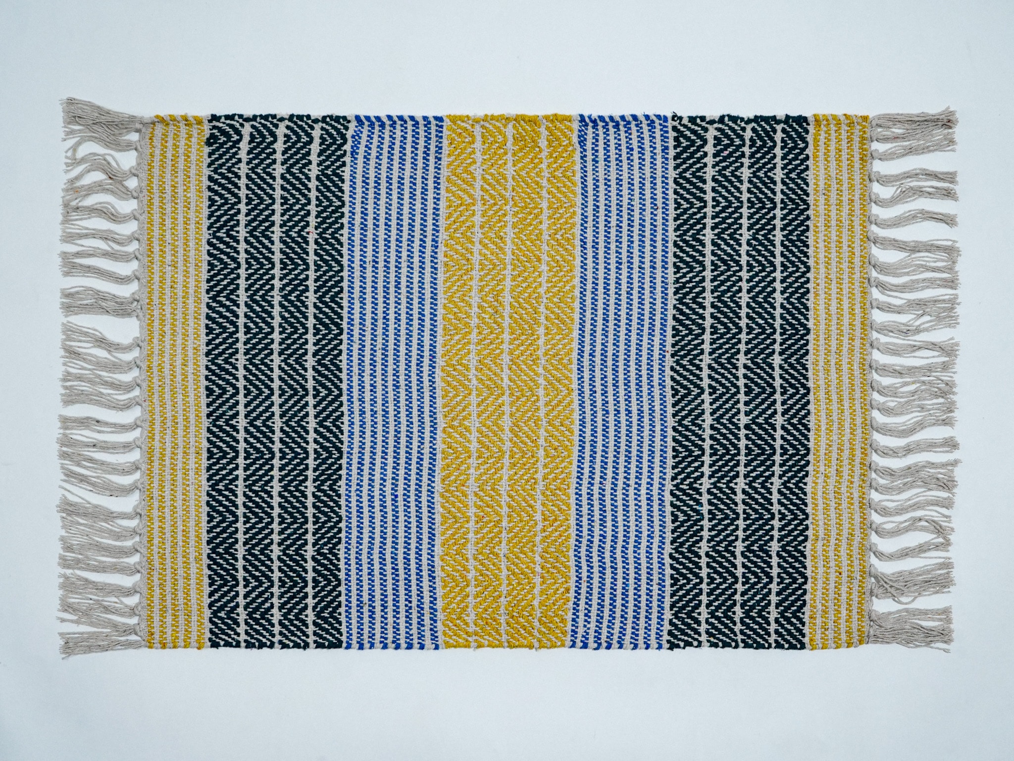 Meher rag rug in yellow colourway styled in a living room setting