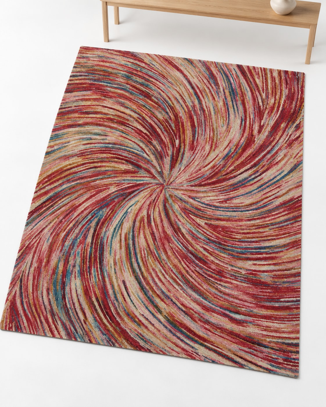 A colourful wool carpet with curved red, cream, ochre and muted blue bands sweeping toward a central point.