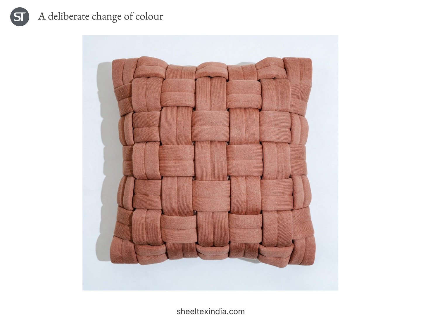 Terracotta cushion cover with wide strips interlaced in a raised grid on a pale background.